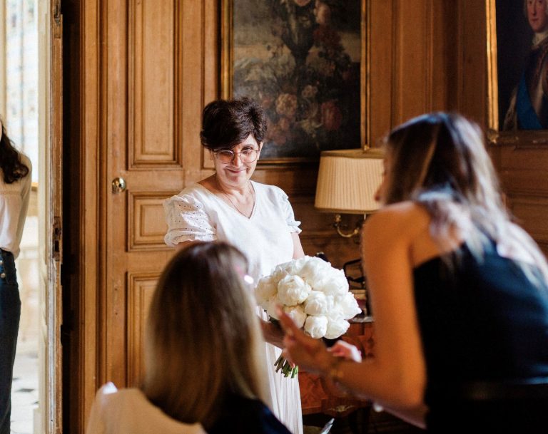 Marie France Cousi, gérante de Artmania remet un bouquet de fleurs à une mariée